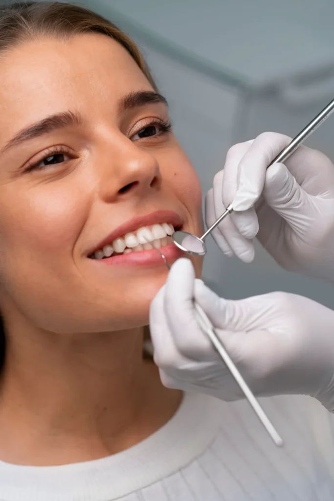 Female patient smiling during a cosmetic dentistry consultation in Chicago with a dental mirror and probe.