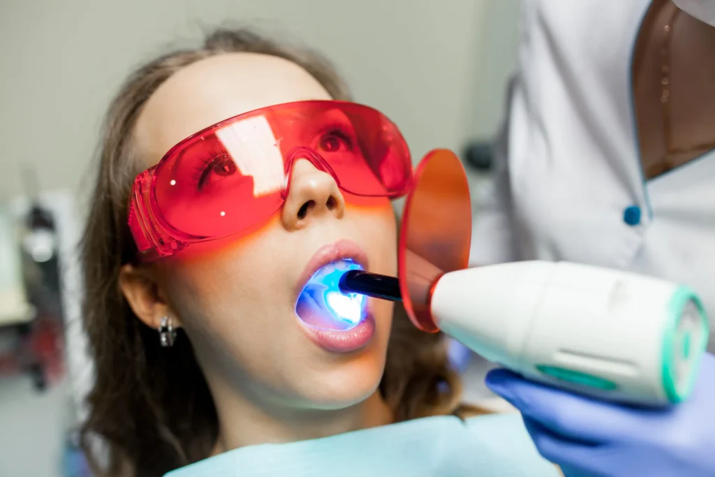 Female patient undergoing teeth whitening light treatment in Chicago for a brighter smile.